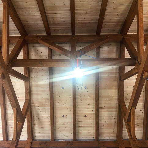 Timber framing in a houses great room.  View of the heavy timbers supporting the roof.  
