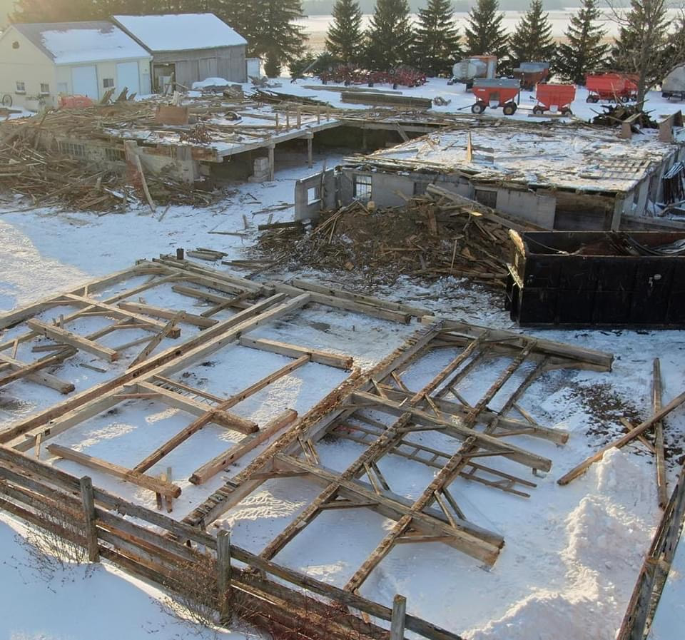 Timer frame barn being relocated.  Timber frames have been placed on the snow covered ground