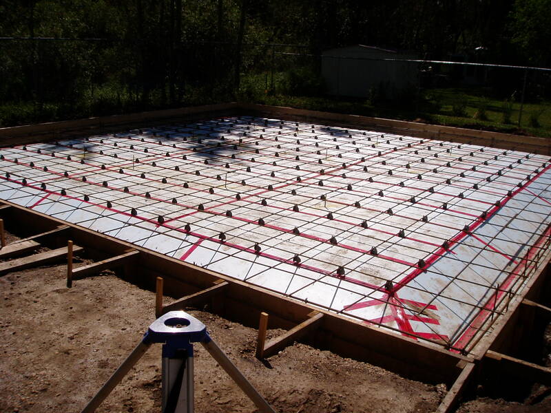 Floating slab foundation with insulation and rebar supported on chairs.  Slab is formed and ready to be poured.