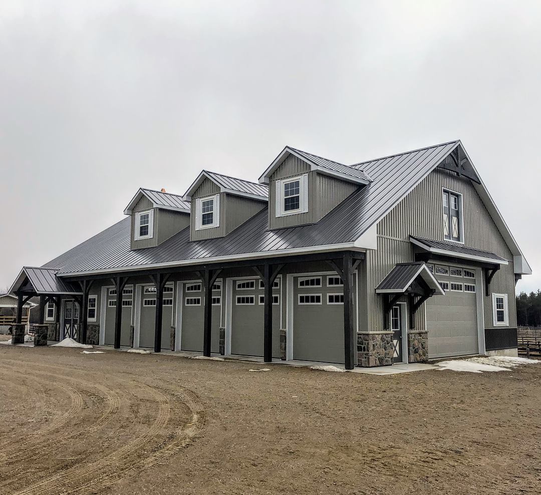 Shed / garage with lots of architectural improvements.  Timber frame entrance, steel roof, stone veneer, 5 overhead doors on the side and 1 on the end.   Roof has 3 dormers and a copula.  Designed as the perfect mancave.    Foundation is a floating slab with in floor heat.