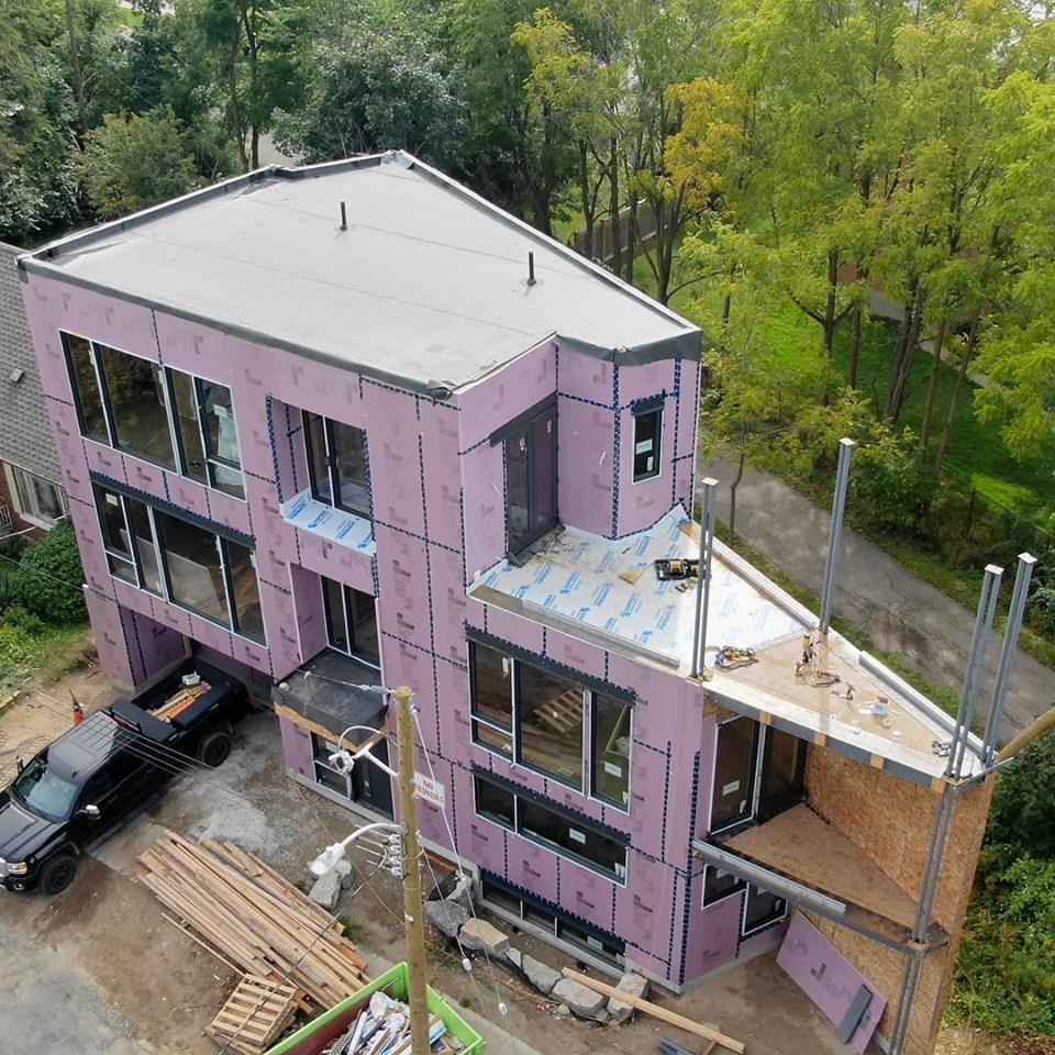 Aerial view of a modern house that is shaped like a piece of pie.  House is 3 storey and located in Kitchener Ontario.  Home is by Neo Developments & Architects.  Flat roof design with a large roof top deck.