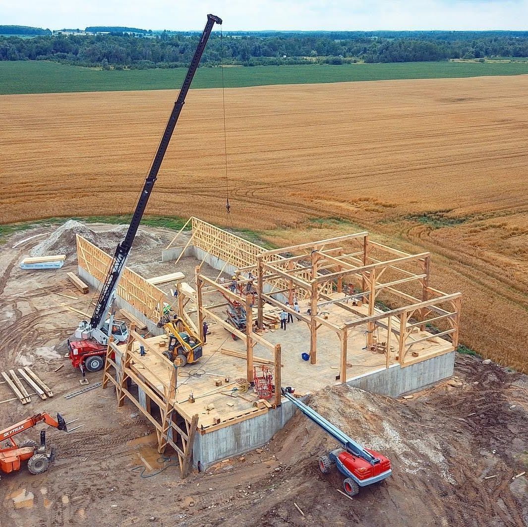 Reconstructing old timber frame structure.  Drone view of crane installed heavy timbers.