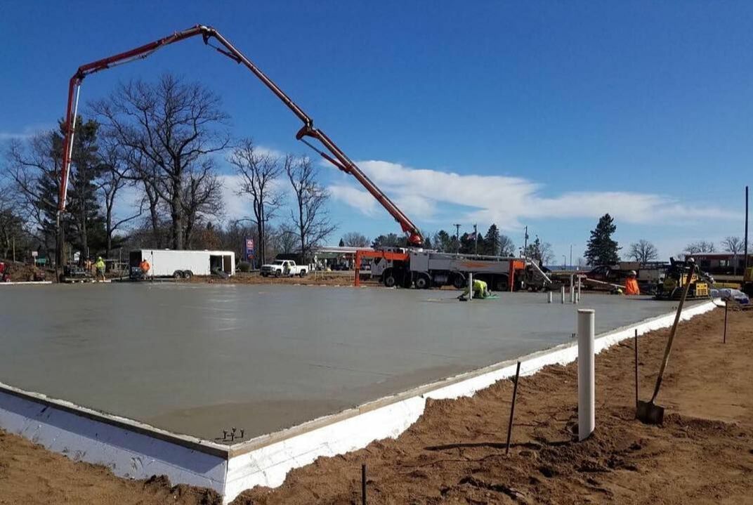 Foundation slab being poured with a pump truck with a long boom.  Pre-eng building slab with insulation.