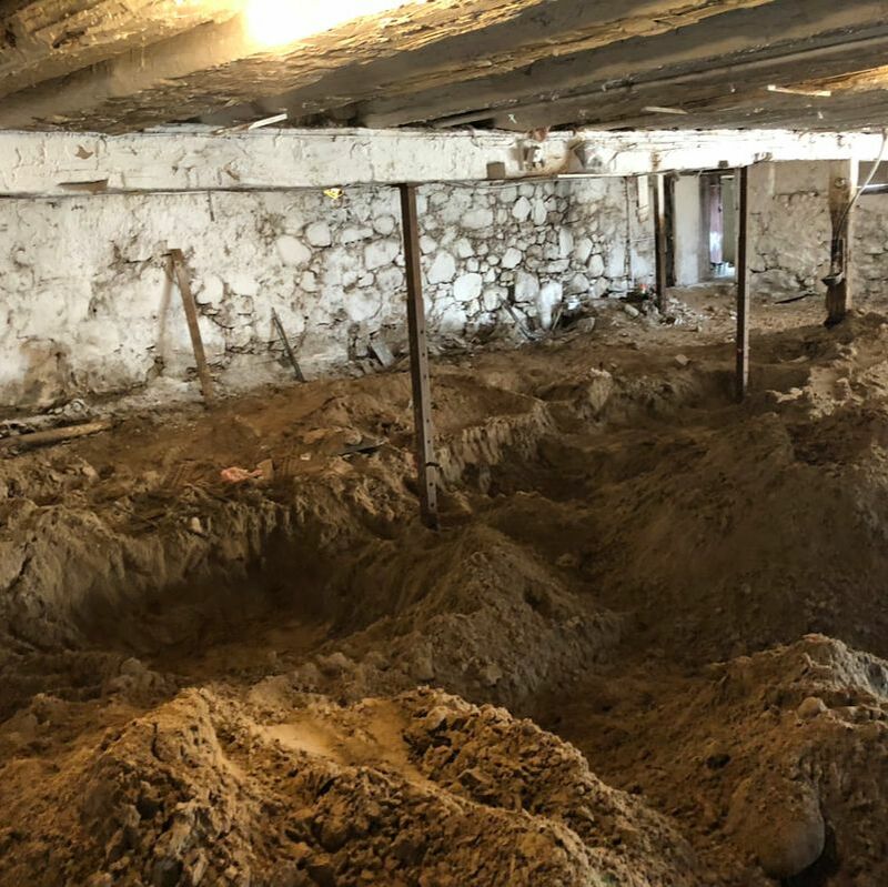 Foundation underpinning and lower the floor in a existing bank barn.  The floor is being excavated and removed from the barn.  